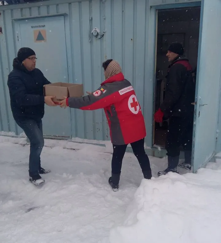 Alimente și haine groase oferite de Crucea Roșie pentru persoanele fără adăpost