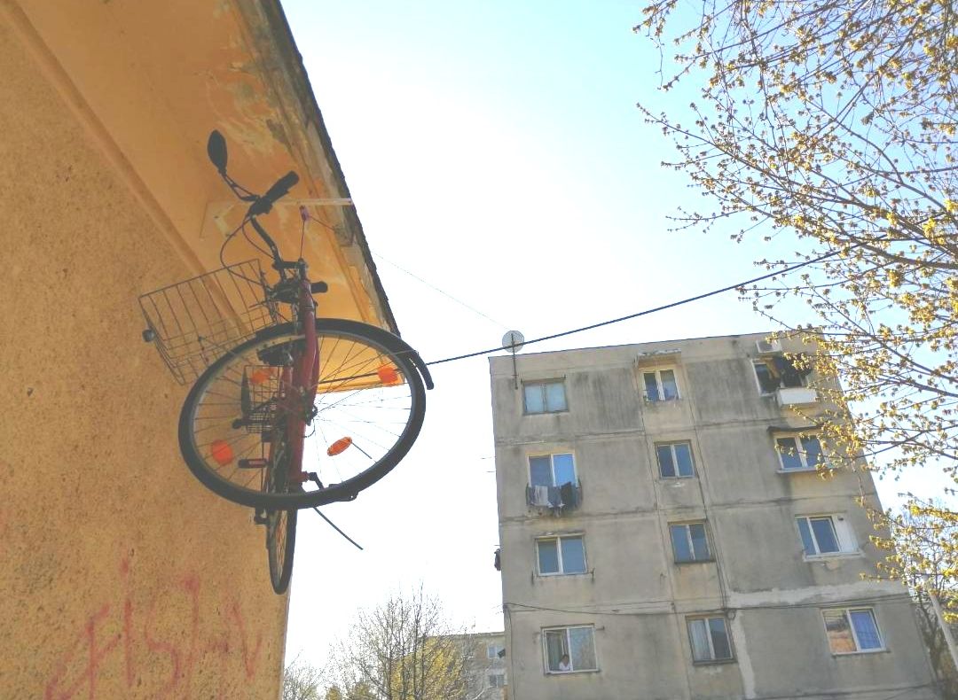 FOTO:De frica hoților, își urcă bicicleta la etajul IV pe sârmă. Până acum a rămas de trei ori fără bicicletă